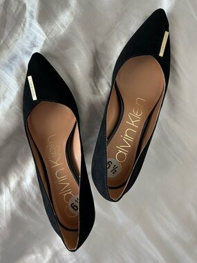 Calvin Klein Women's Black Pointed Toe Slip-On Flats with Gold Logo Plaque